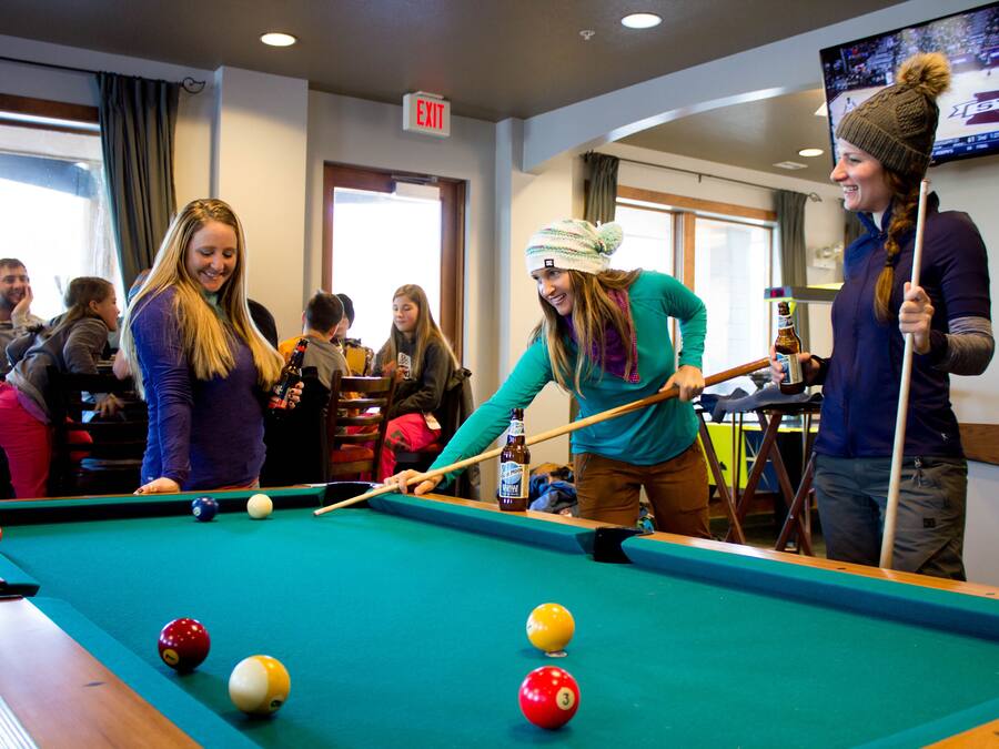 A pool table with balls and a person playing.