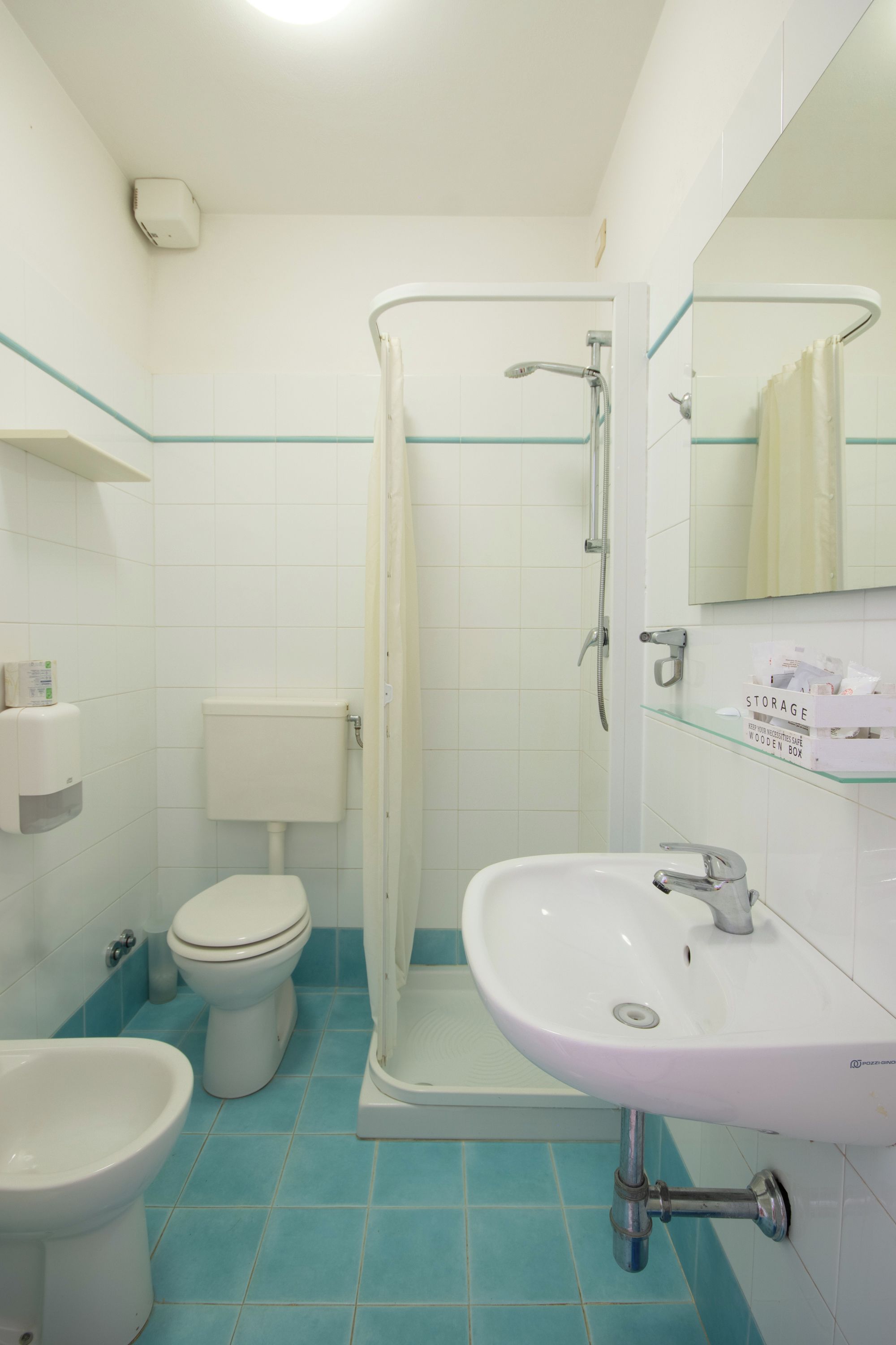 A bathroom with a toilet, bidet, and a shower stall.