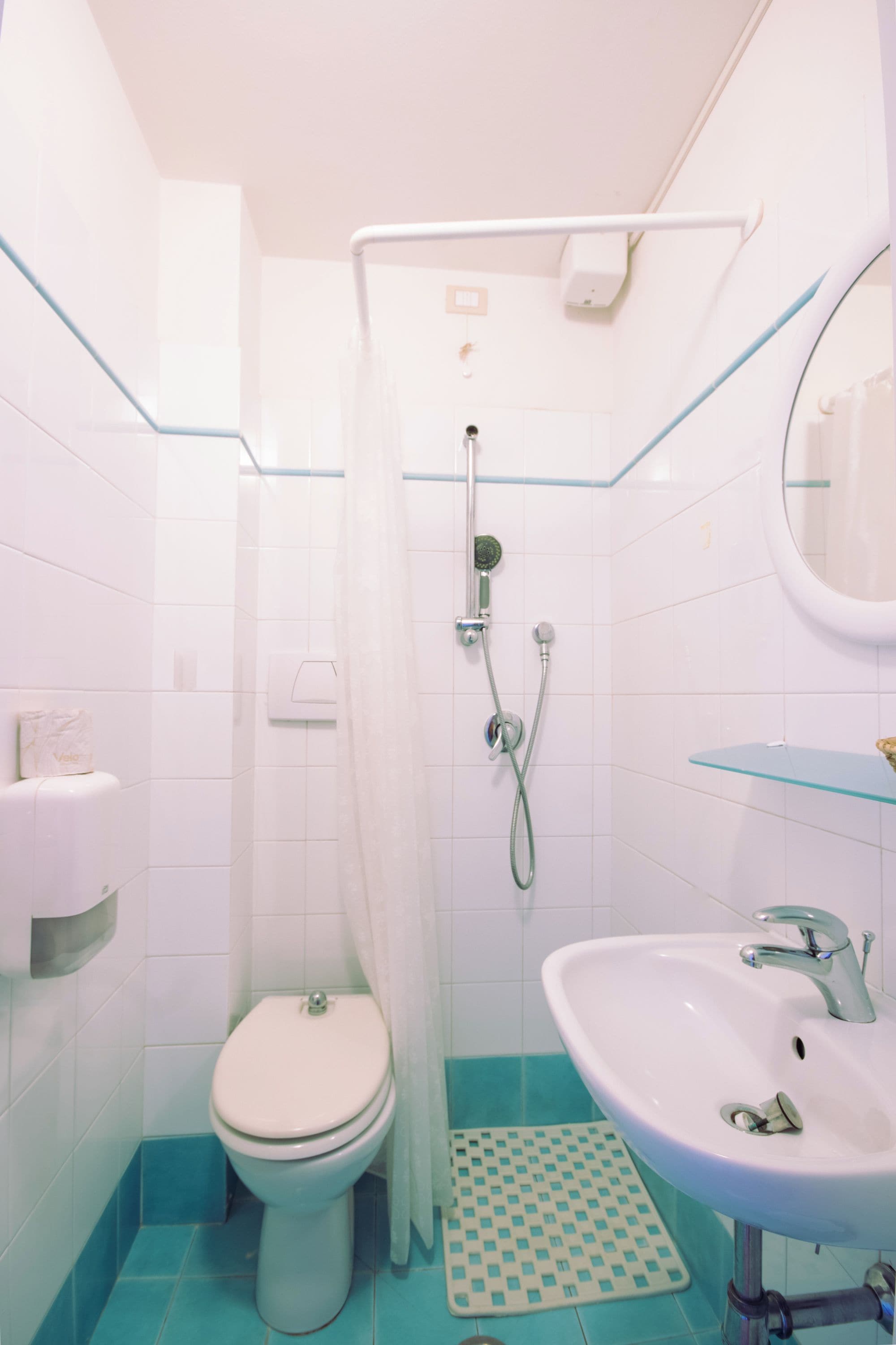 Une salle de bain avec des toilettes, une douche et un lavabo.