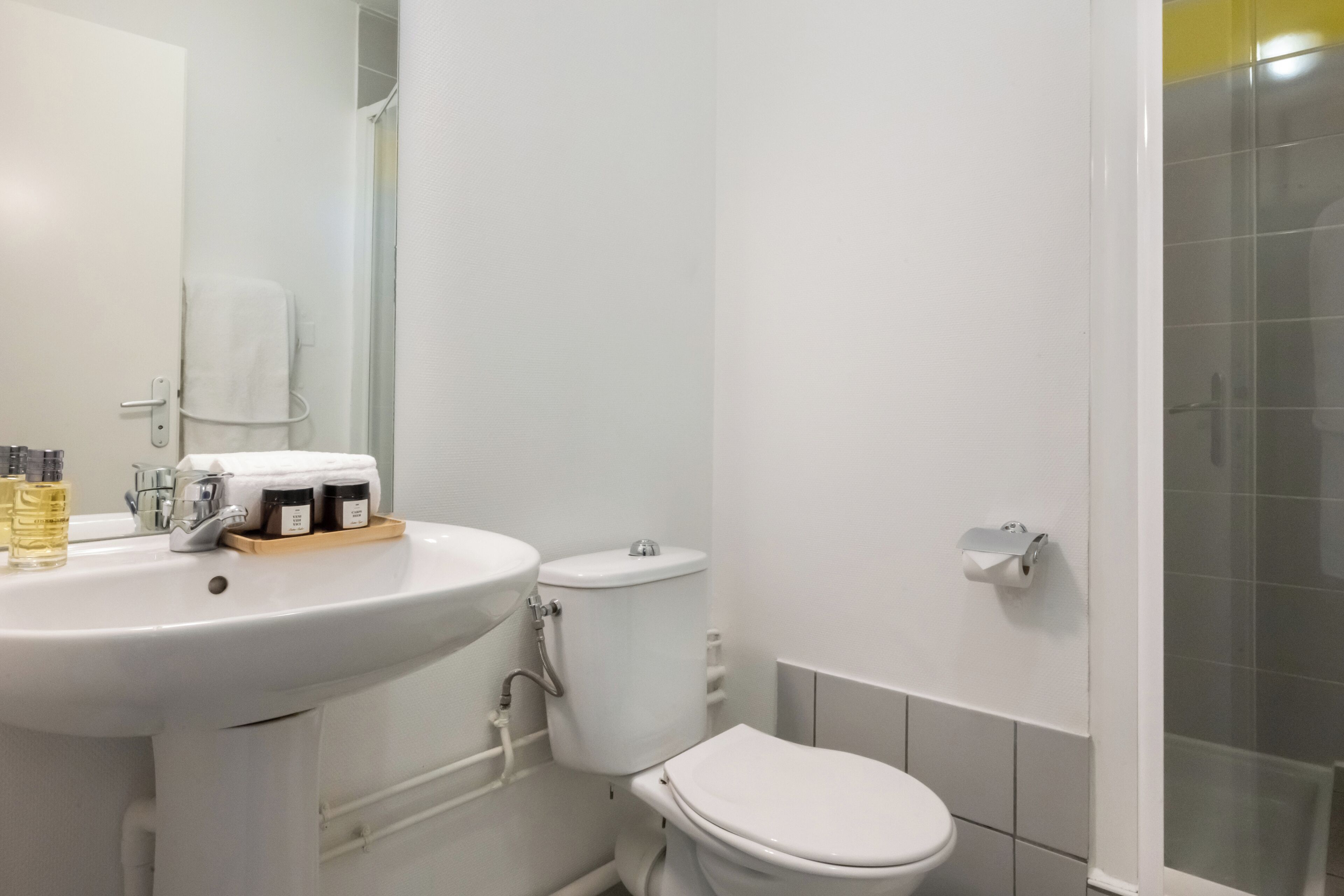 A bathroom with a white sink, toilet, and shower.