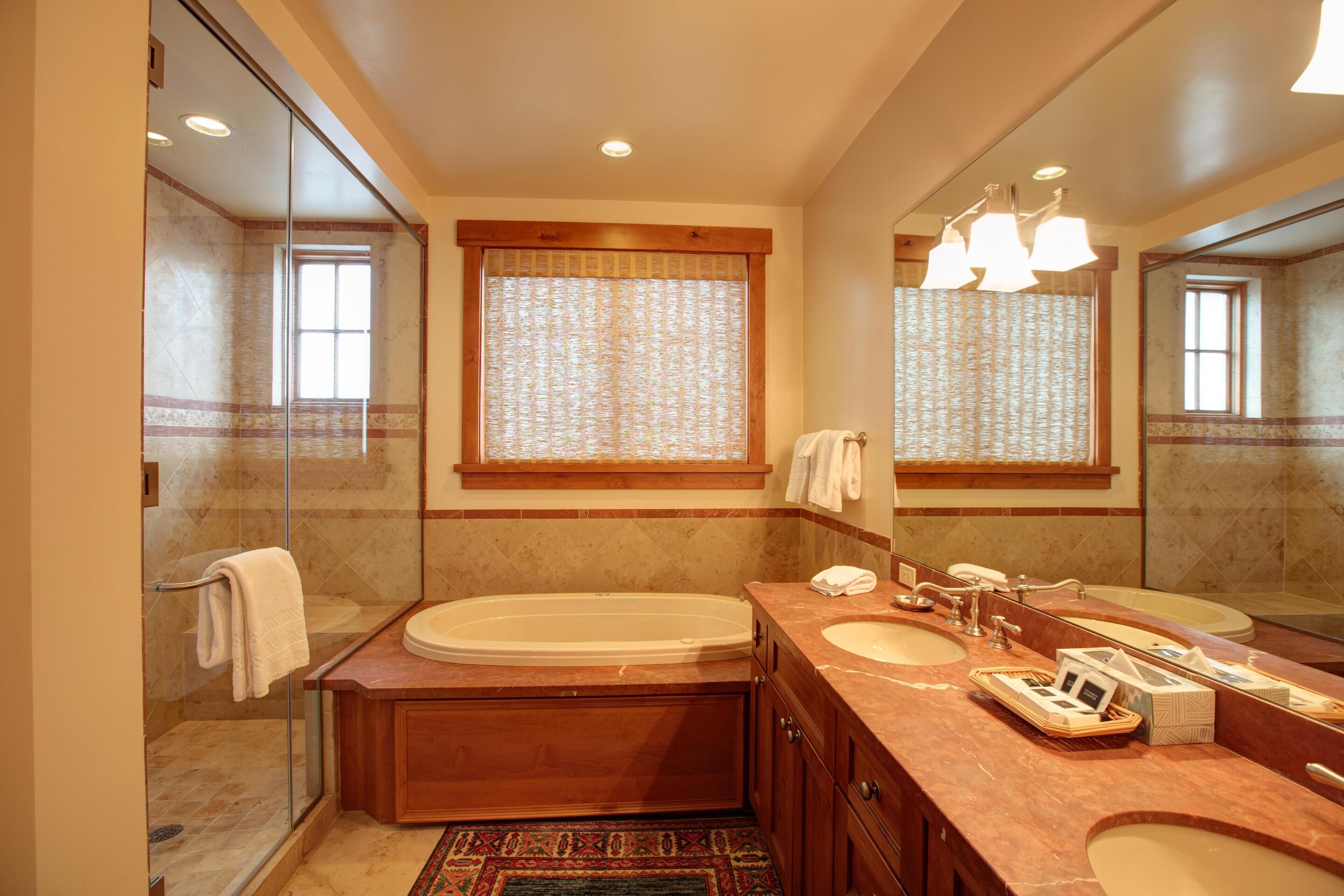 Une salle de bain moderne avec une baignoire, un double vasque et un grand miroir.