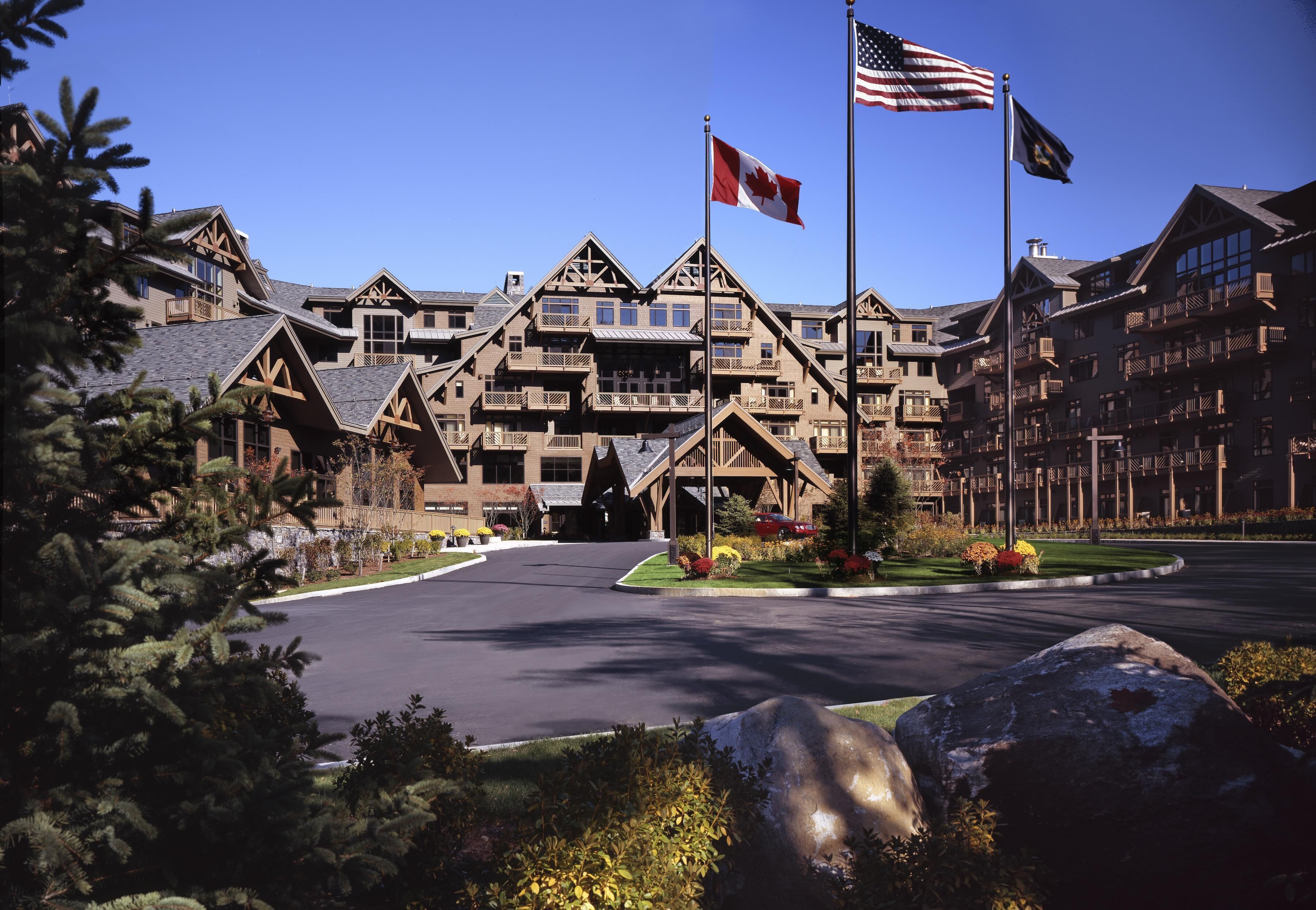 A lodge with a central entrance, multiple balconies, and flags.