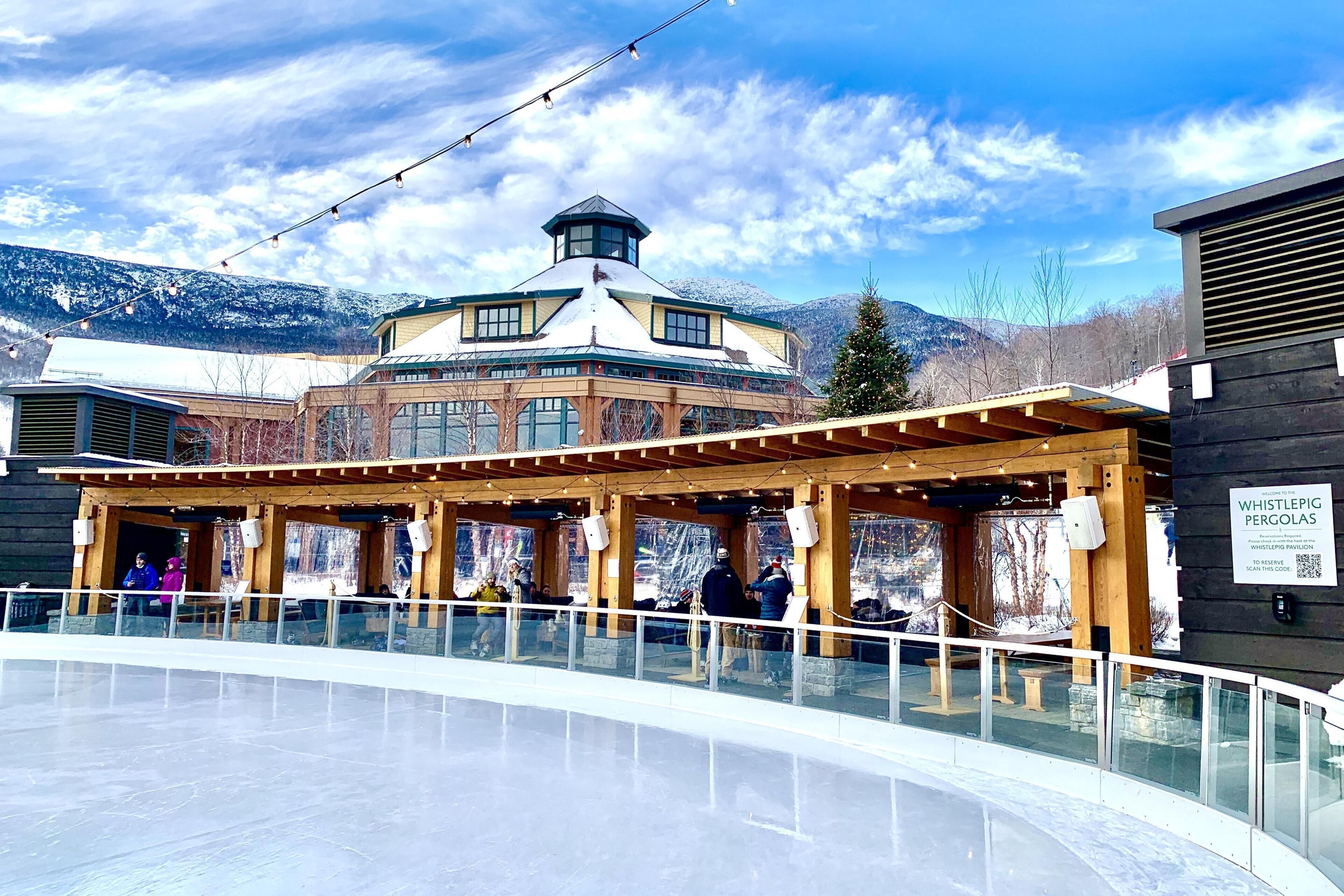 A building with a distinctive tower, a covered outdoor seating area, and a glass railing in front.