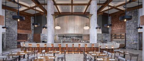 Un restaurante espacioso con techos altos, vigas a la vista, paredes de piedra y varias zonas de estar.