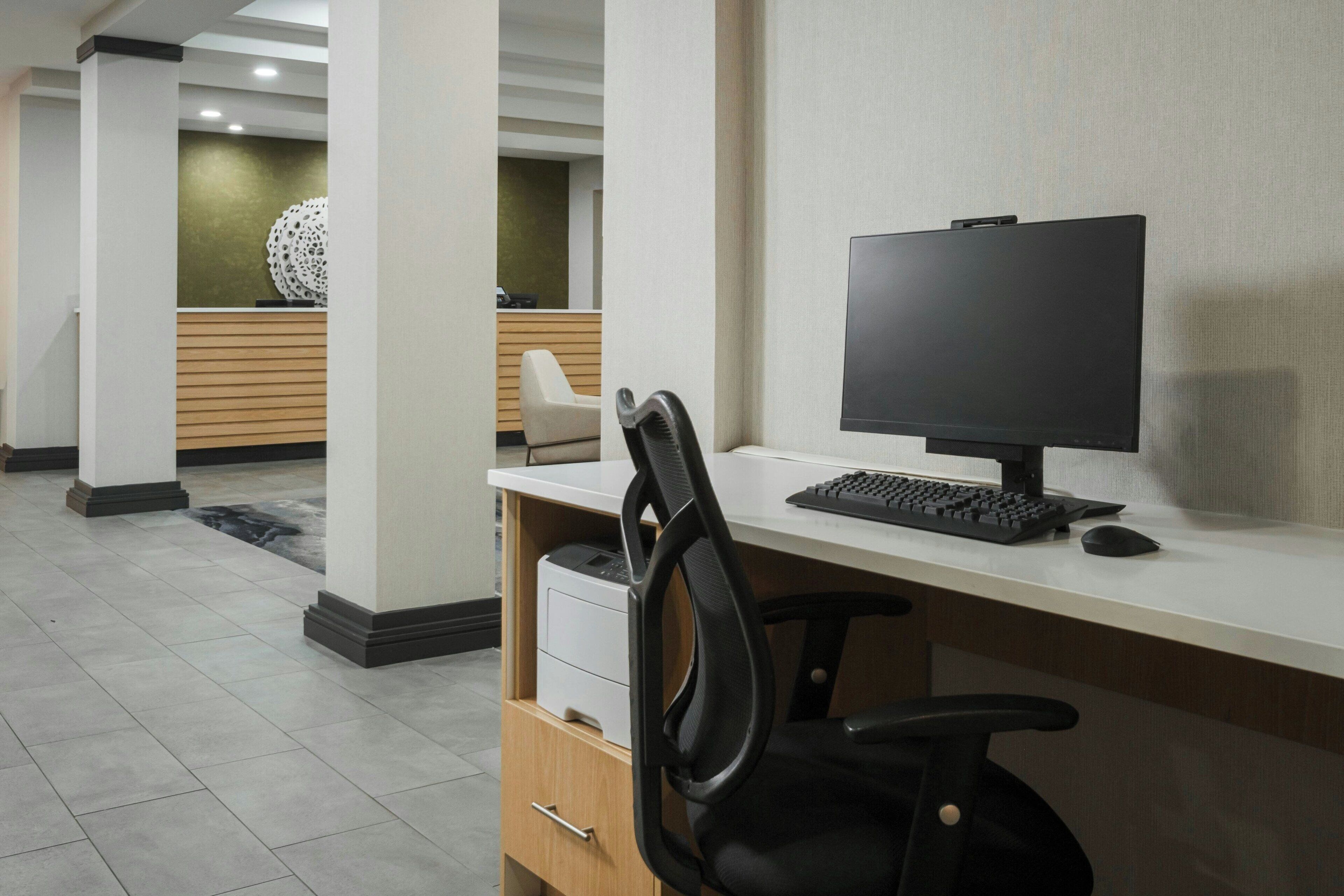 Un espacio de oficina moderno con escritorio, computadora y silla.