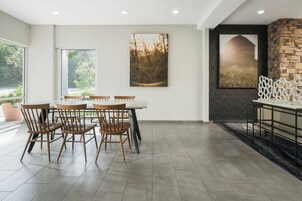 Un comedor con una mesa y sillas, una chimenea y obras de arte en las paredes.