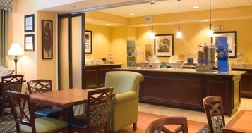Vestíbulo de hotel con recepción, zona de estar y varios servicios.