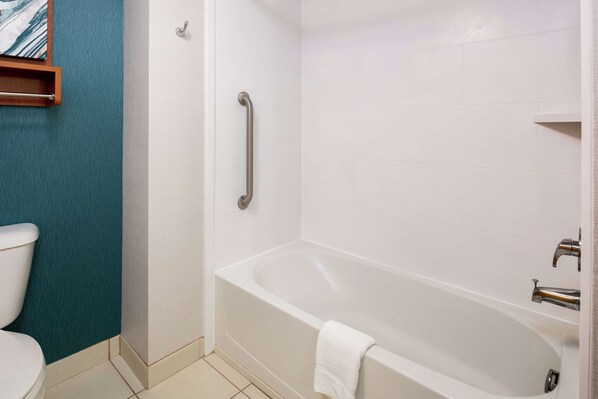 Baño con bañera, inodoro y ducha con baranda.