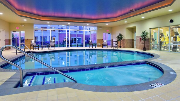 An indoor swimming pool with a clear view of the adjacent building and seating area. - Homewood Suites by Hilton Virginia Beach/Norfolk Airport (Virginia Beach)