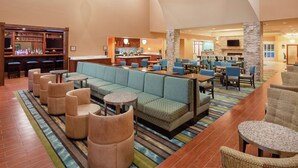 A spacious lobby with a bar area, seating arrangements, and a fireplace. - Homewood Suites by Hilton Virginia Beach/Norfolk Airport (Virginia Beach)