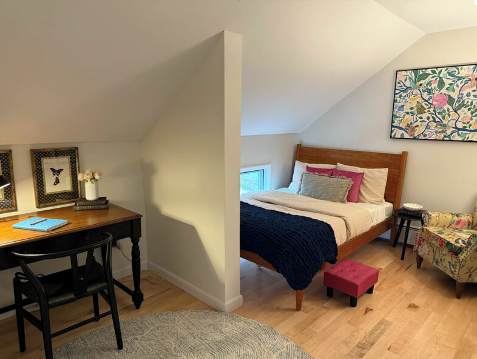 Un dormitorio con cama, mesitas de noche, escritorio y una silla.