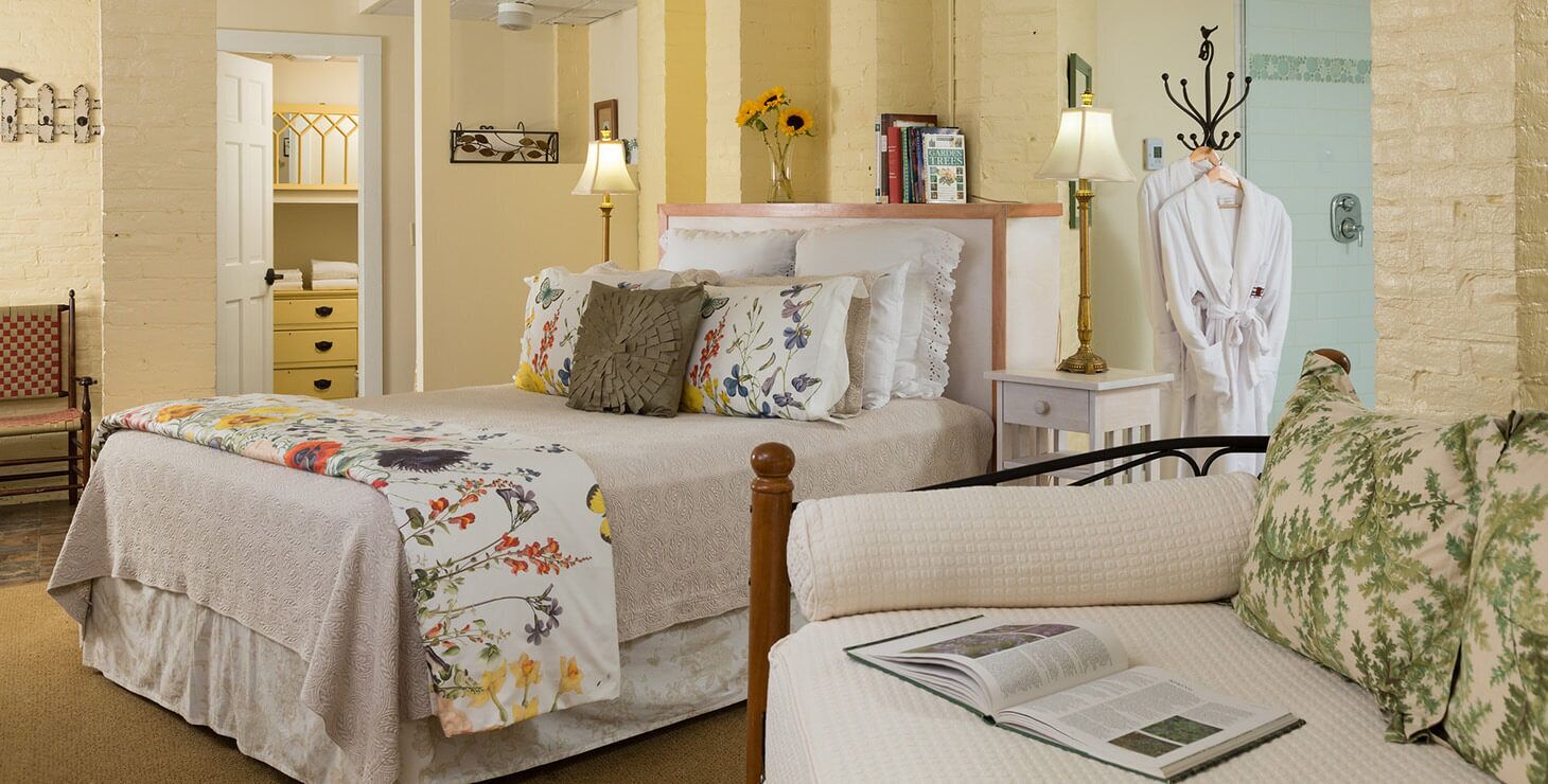 Une chambre avec deux lits, une table de chevet avec des lampes, une armoire et une chaise.