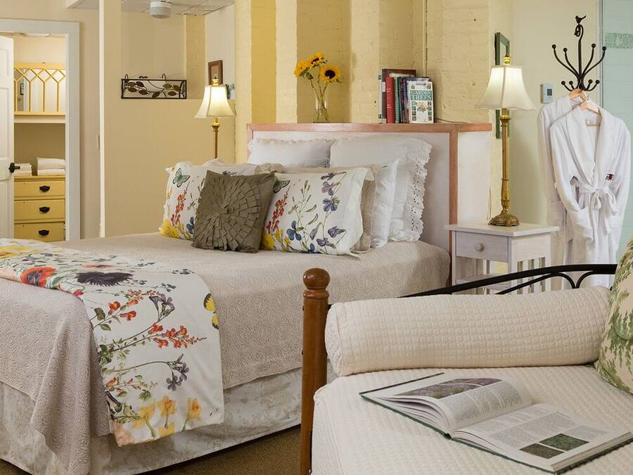 Une chambre avec deux lits, une table de chevet avec des lampes, une armoire et une chaise.