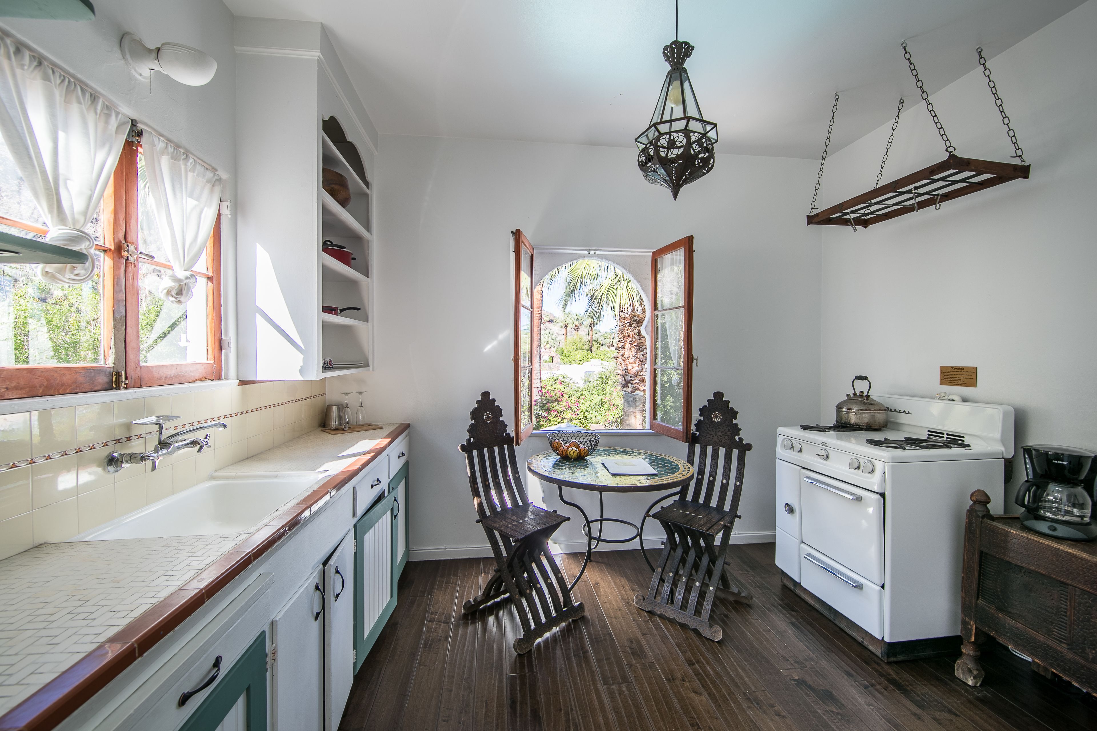 A kitchen with white cabinets, a stove, and a dining table with chairs.
