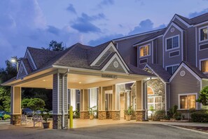 A hotel with a covered entrance, stone accents, and a sign indicating 'Clearance 11th Floor'. - Microtel Inn & Suites by Wyndham Jacksonville Airport (Jacksonville)