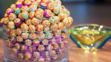 A clear glass container filled with colorful wrapped candies.