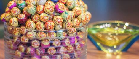 A clear glass container filled with colorful wrapped candies.
