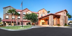 A hotel with a modern design, featuring a stone facade, multiple balconies, and a central entrance with a glass door. - Comfort Suites Goodyear - West Phoenix (Goodyear)
