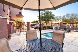A patio area with a pool, outdoor seating, and a covered table. - Comfort Suites Goodyear - West Phoenix (Goodyear)