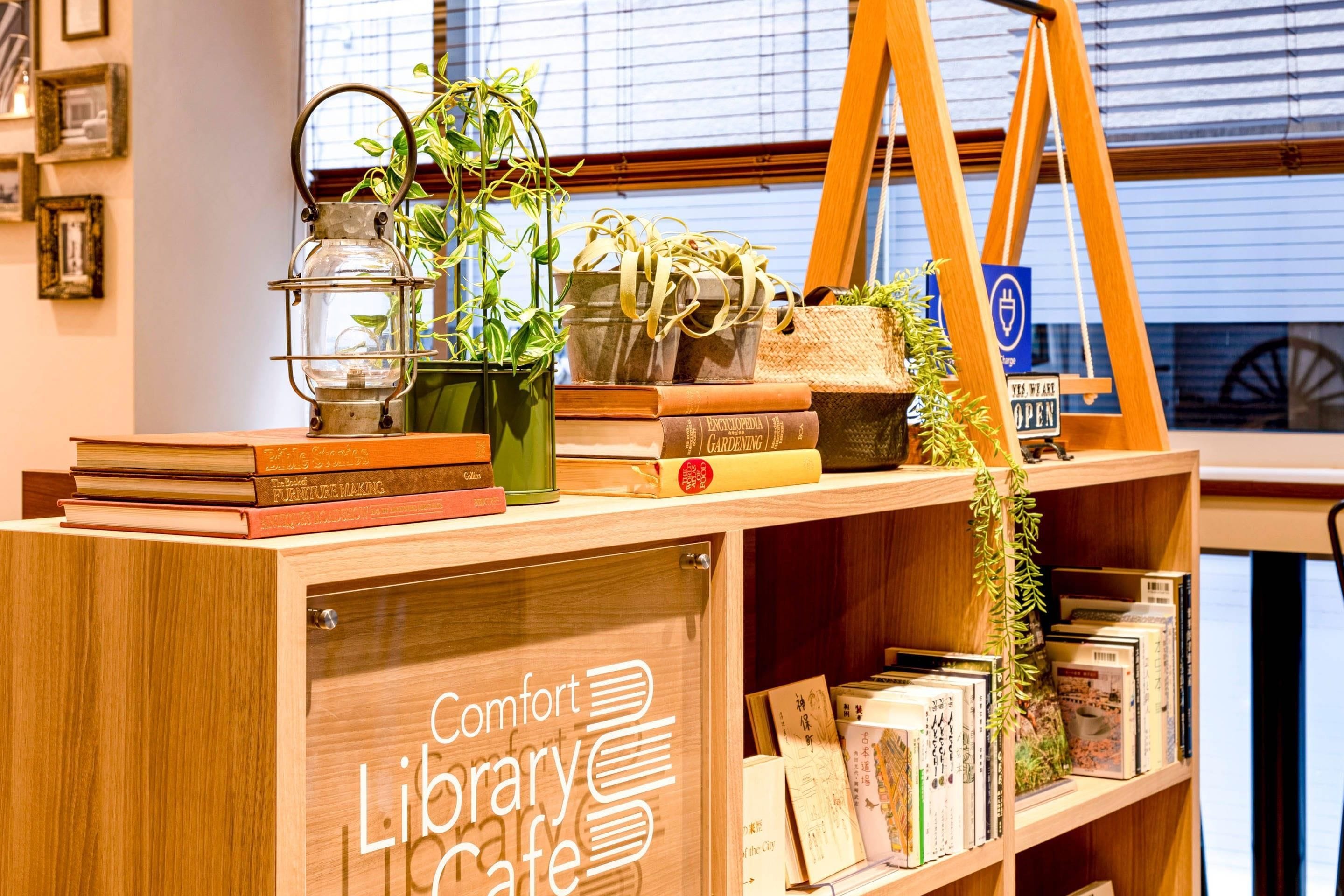 Una estantería de madera con libros, un farol y plantas.