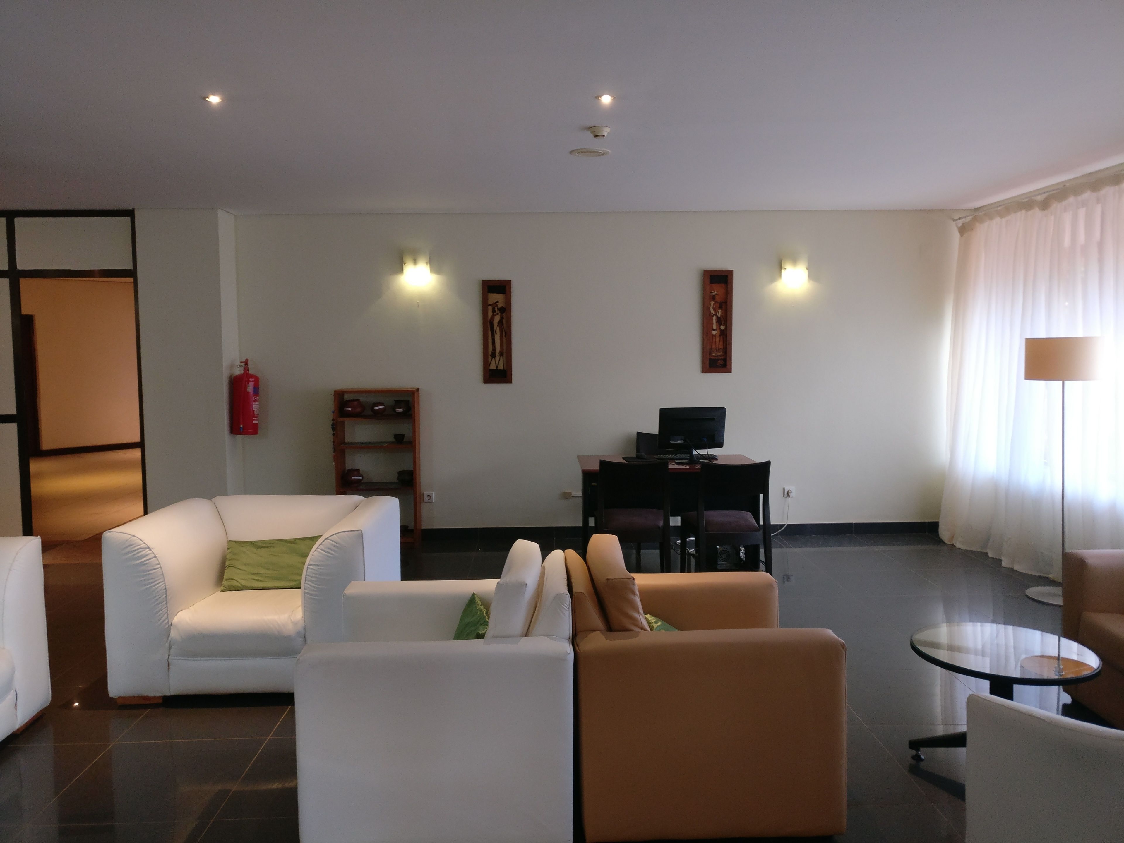 Una sala de estar moderna con un juego de sofá, una mesita y un escritorio con una computadora.