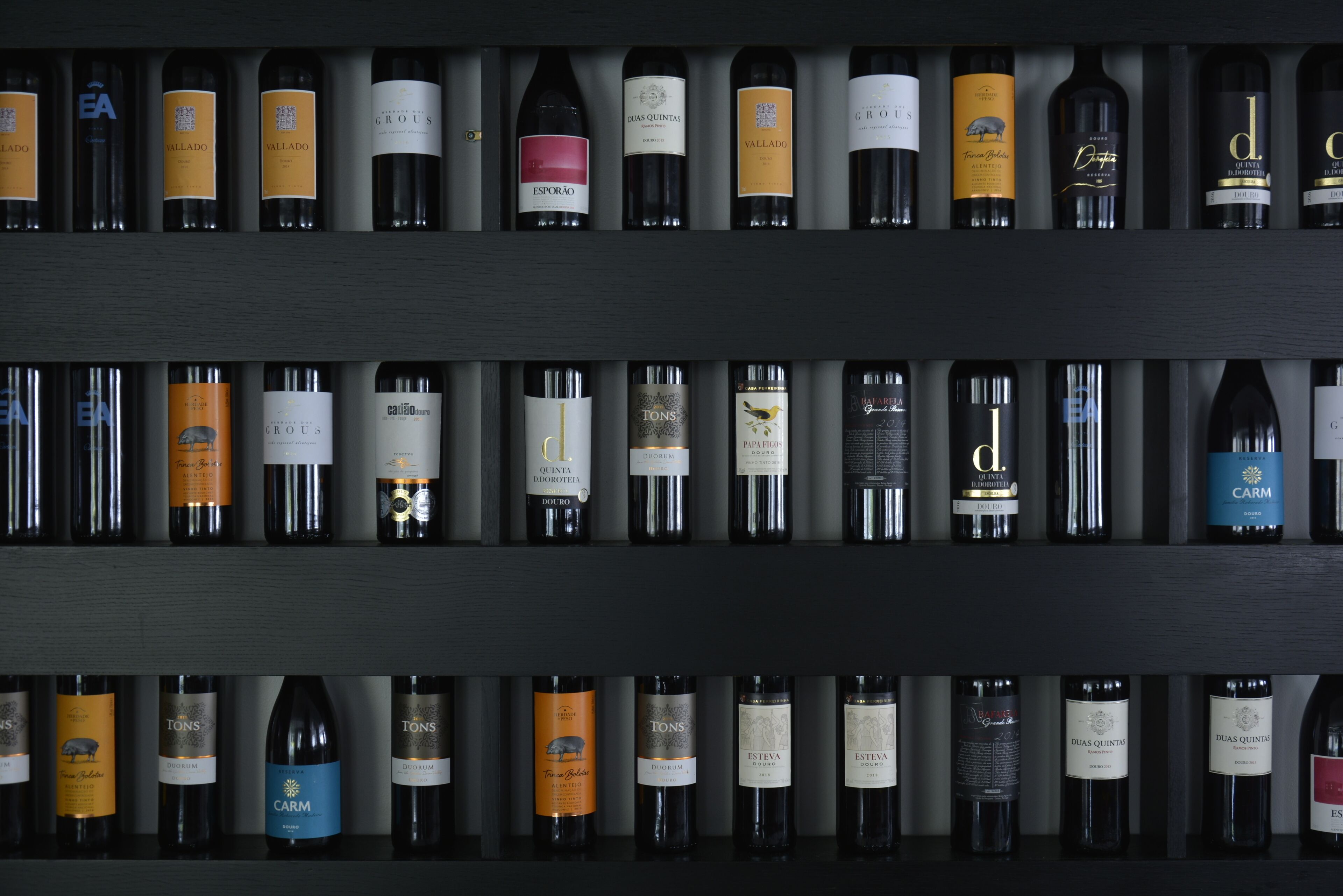 A wine rack with various bottles of wine.