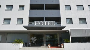 Ein modernes Hotelgebäude mit einem gut sichtbaren „HOTEL“-Schild über dem Eingang.
