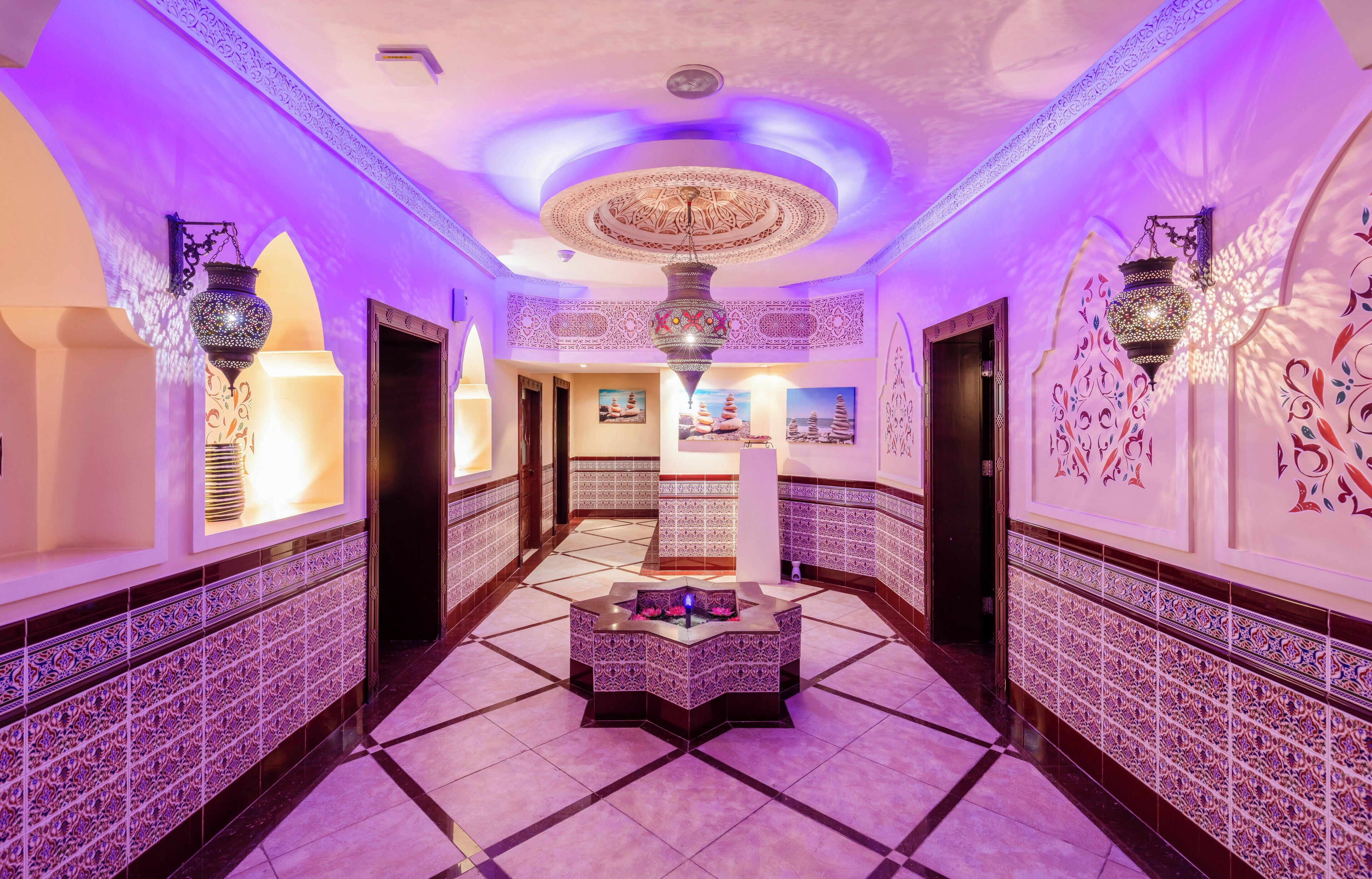 A hallway with patterned walls, a central decorative piece, and a tiled floor.