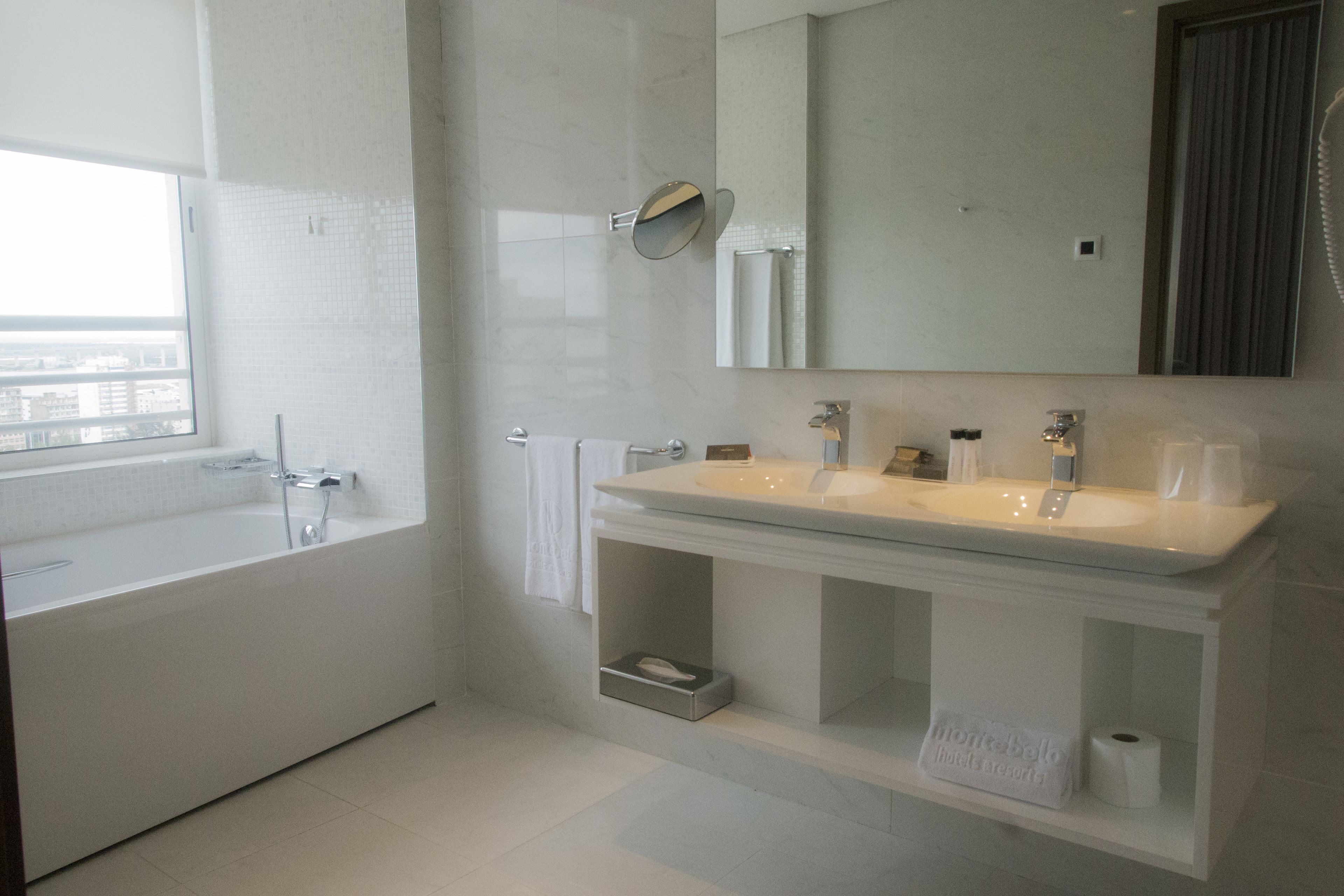A modern bathroom with a bathtub, a sink, and a mirror.