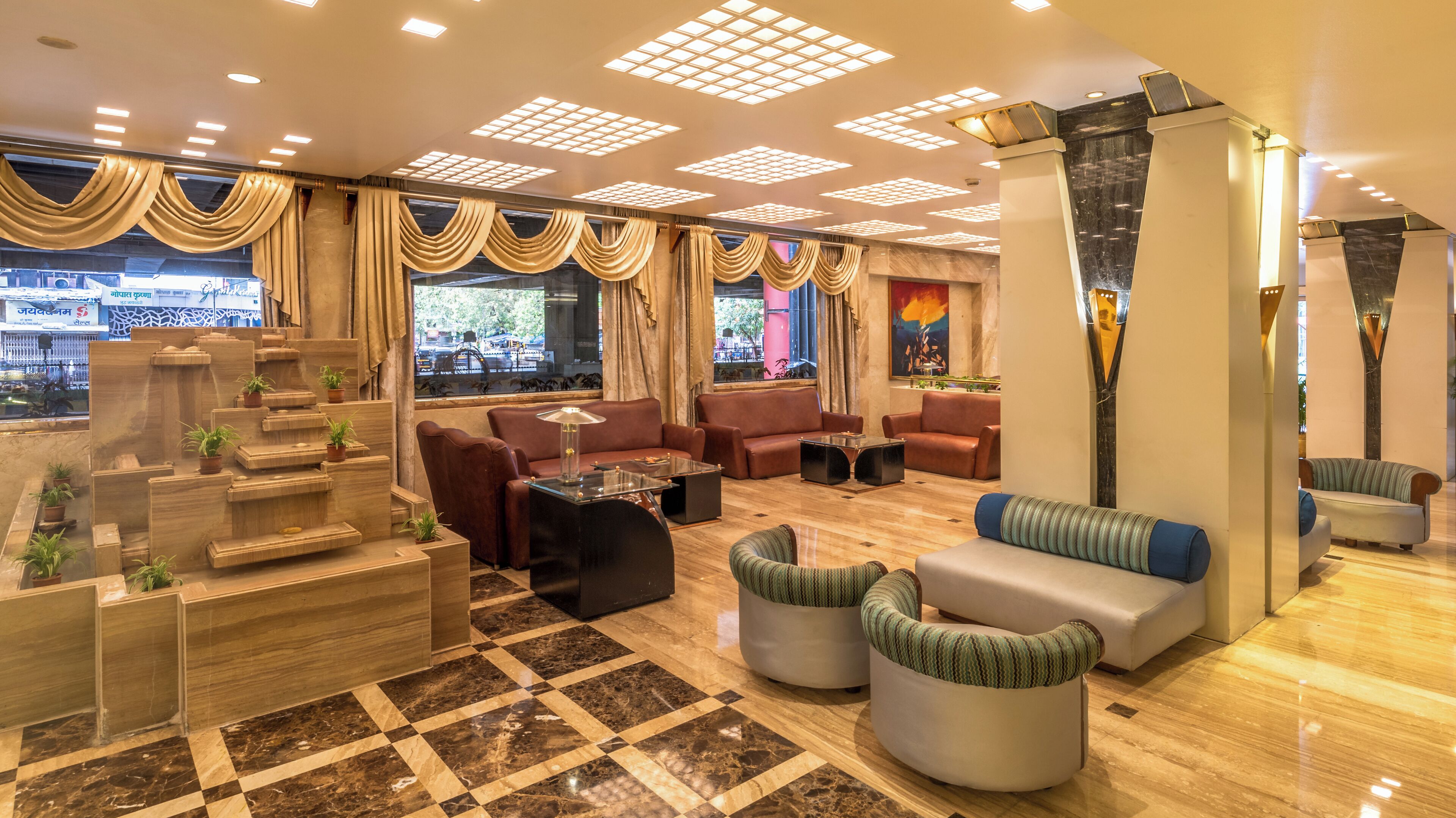 A spacious lobby with a checkered floor, leather sofas, and a central coffee table.
