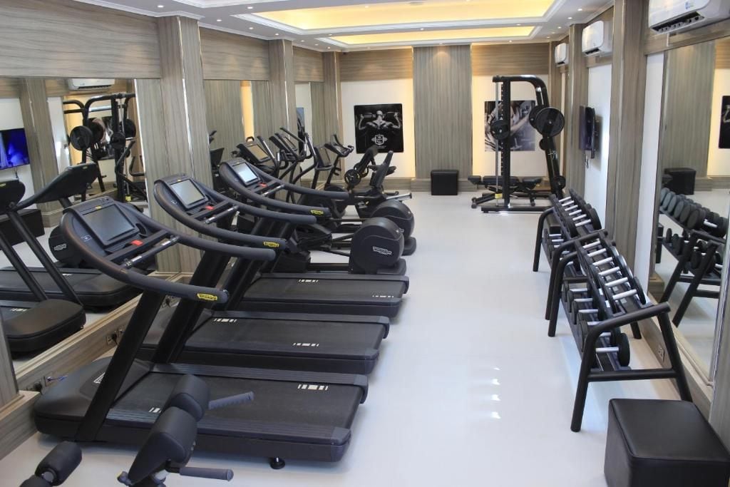A gym with multiple treadmills, weight machines, and dumbbells.