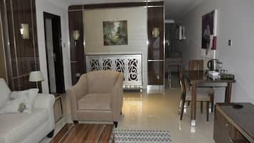 Una sala moderna con sofá, sillón y comedor con mesa y sillas.