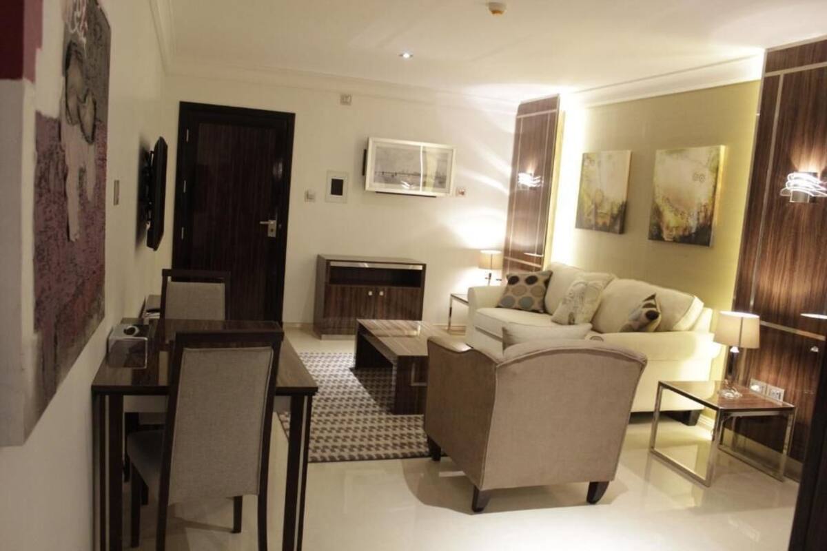 Uma sala de estar moderna com sofá, mesa de centro e espaço para refeições.
