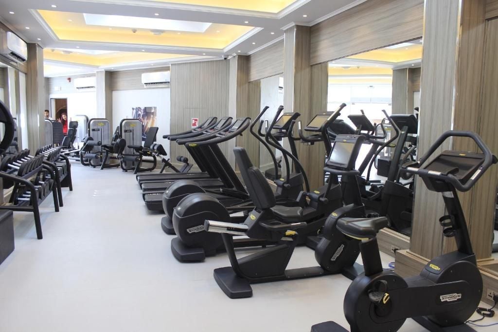 A gym with multiple treadmills, stationary bikes, and weight machines.