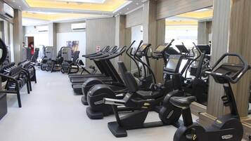 A gym with multiple treadmills, stationary bikes, and weight machines.