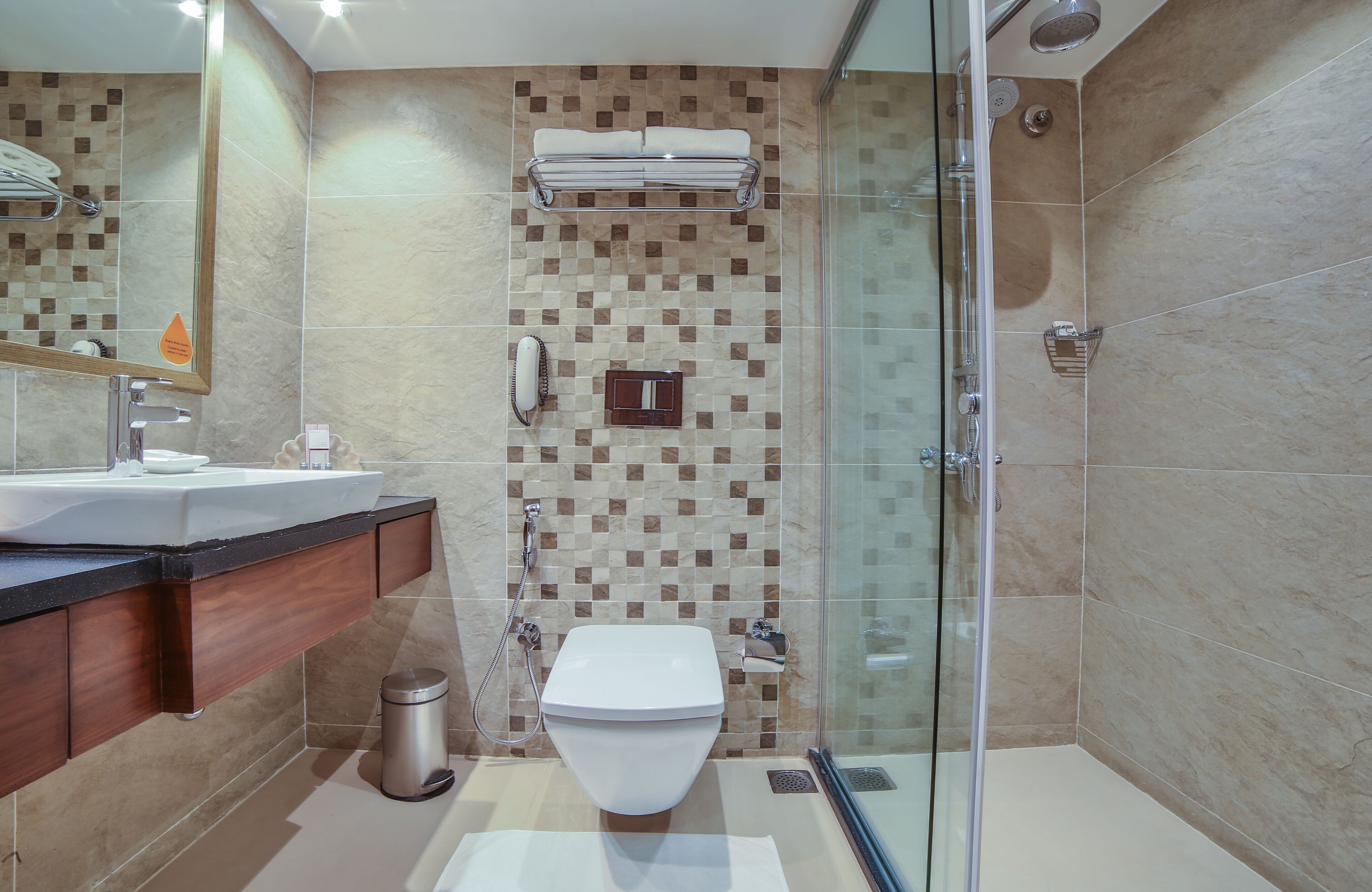 A modern bathroom with a glass shower enclosure, a built-in sink, and a vanity with a mirror.