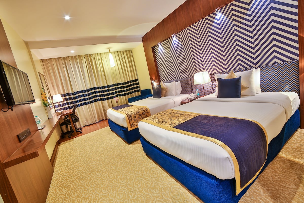 A hotel room with a large bed, a desk, and a television.
