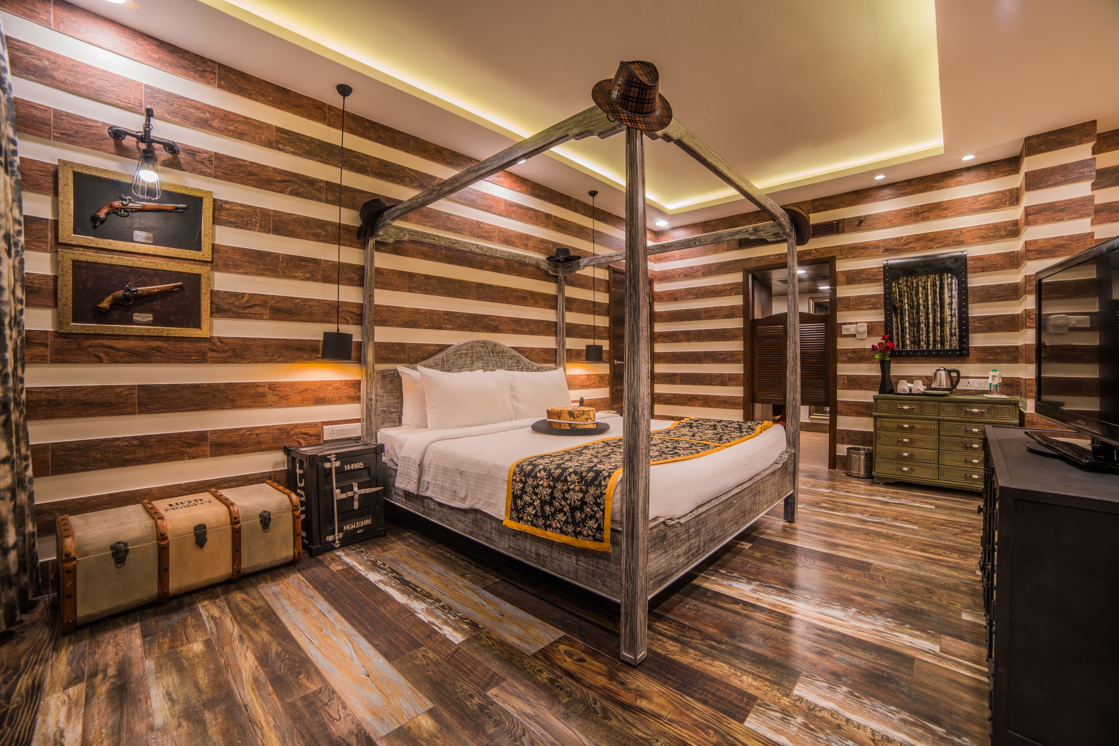 A room with a four-poster bed, wooden panel walls, a mounted television, and a wooden floor.