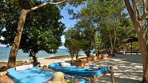 A beachside relaxation area with hammocks and sun loungers, surrounded by trees and overlooking the sea. - Fumba Beach Lodge (Fumba)