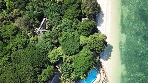 An aerial view of a tropical resort with a swimming pool, lush greenery, and a beach. - Fumba Beach Lodge (Fumba)