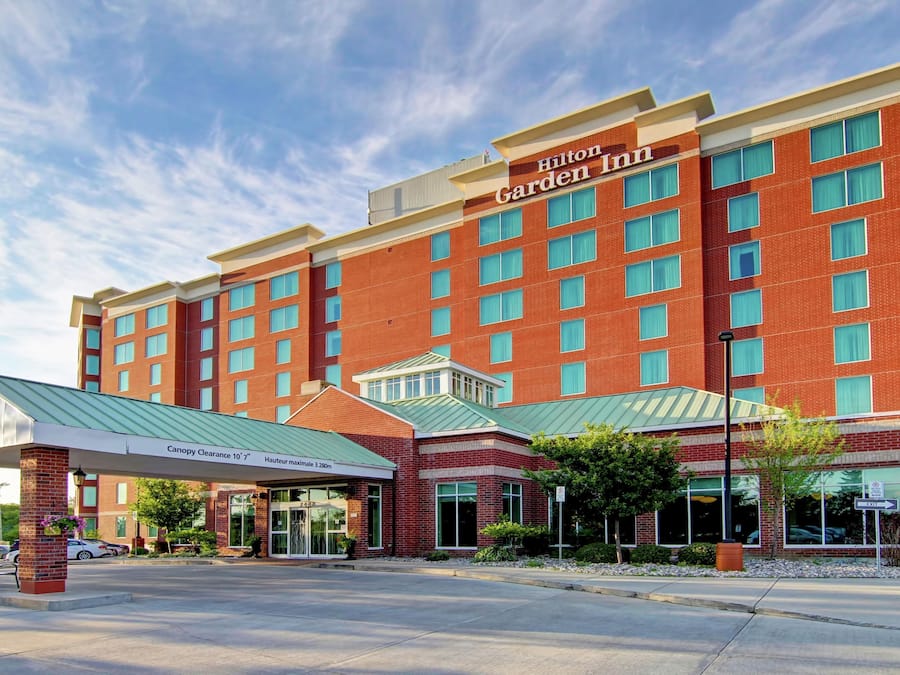 Un Hilton Garden Inn con fachada de ladrillo, varias ventanas y una entrada cubierta.