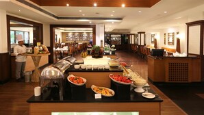 Montaje de bufé con diferentes alimentos y un chef preparándolos.