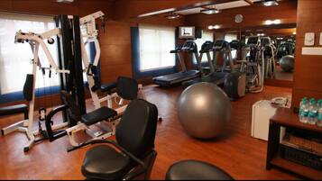 Un gimnasio con cintas de correr, pelotas de ejercicio y máquinas de pesas.