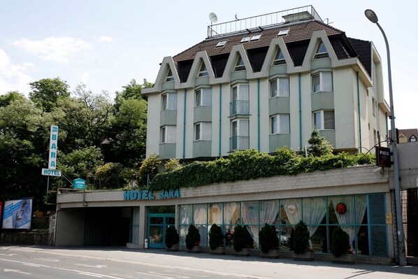 A hotel with a modern facade, multiple windows, and a sign indicating it is a hotel. - Hotel Bara Junior (Budapest)
