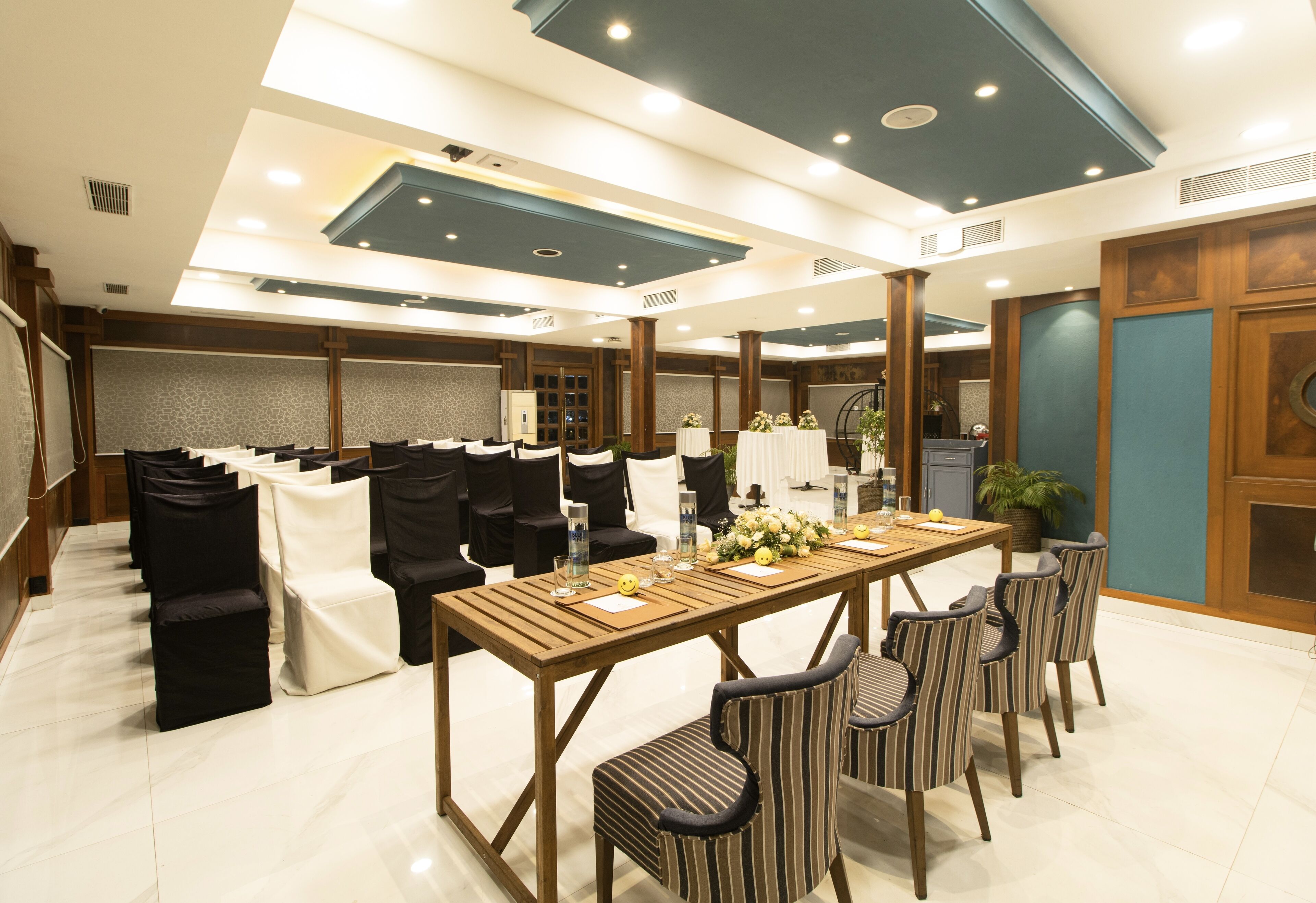 A conference room with a long table, chairs, and a stage area.
