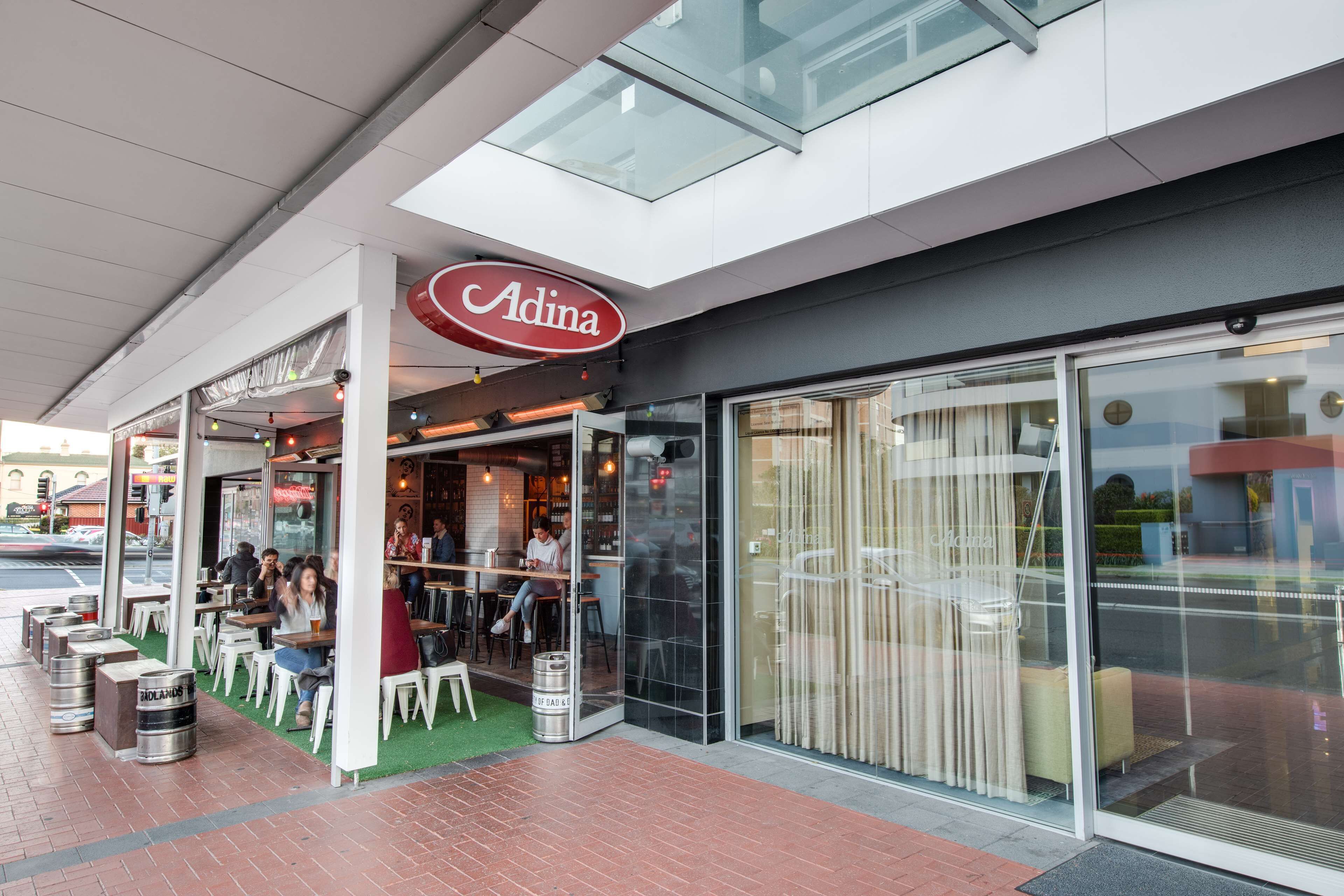 Restaurant Adina met terras en glazen gevel.