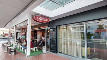 Restaurant Adina met terras en glazen gevel.