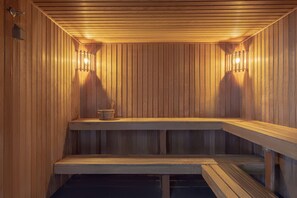Una sauna de madera con bancos y luces en la pared.