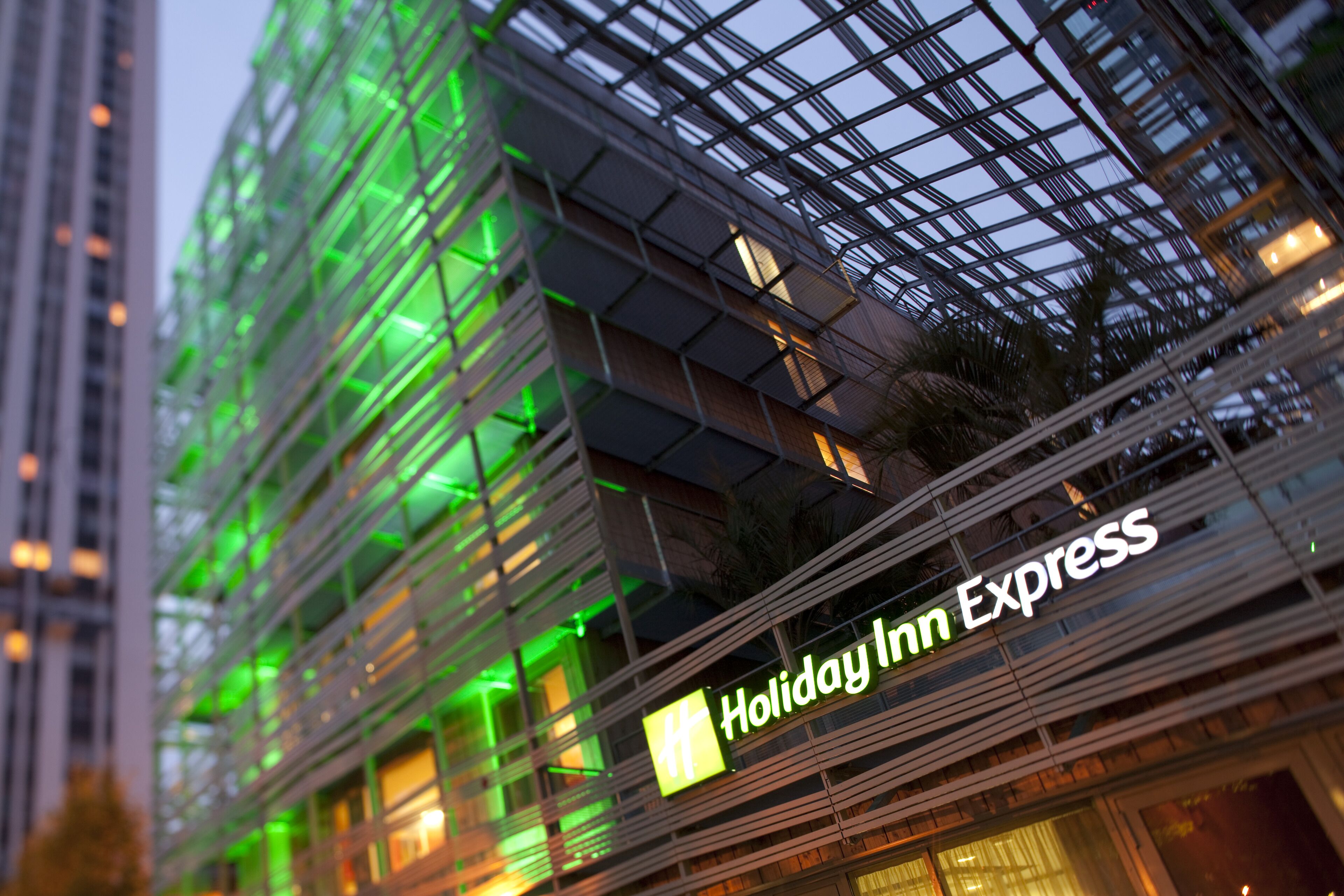 A multi-story building with a glass facade and a sign for Holiday Inn Express.