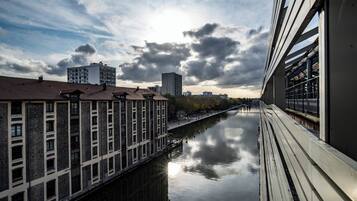 A river with buildings on one side and a modern structure on the other.